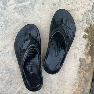 Black oofo flip flops